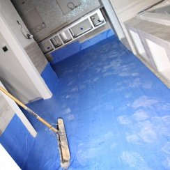 An under-construction room covered with a blue slip resistant floor protector