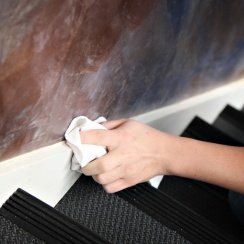Cleaning baseboard with a painter's towel