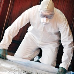 Worker cleaning in a body barrier coverall