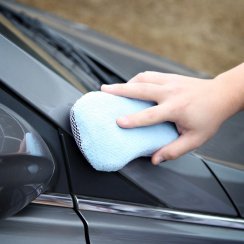 Scrubbing a car with a sponge