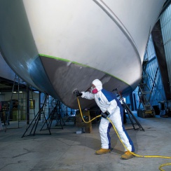 painting a boat in a tyvek dual suit