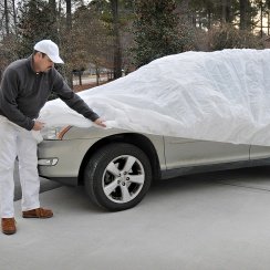 man putting on car cover