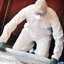 Worker cleaning in a body barrier coverall