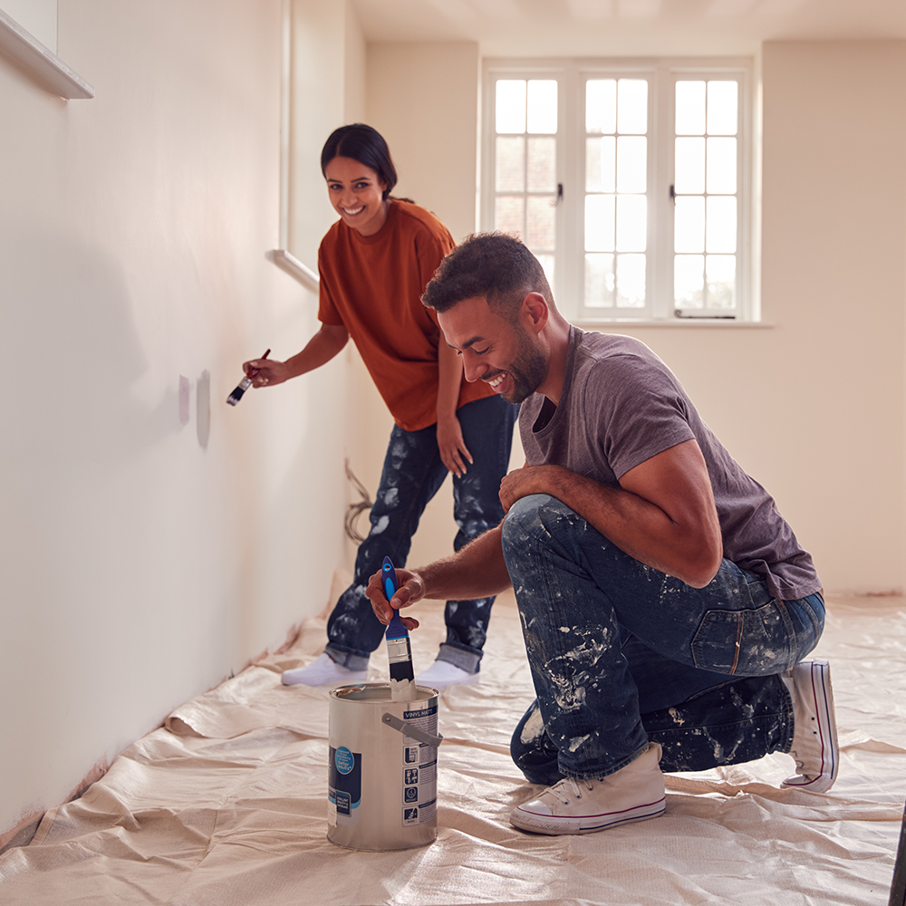 couple painting a wall in a house
