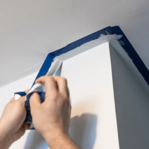 hands removing blue painter's tape at an angle